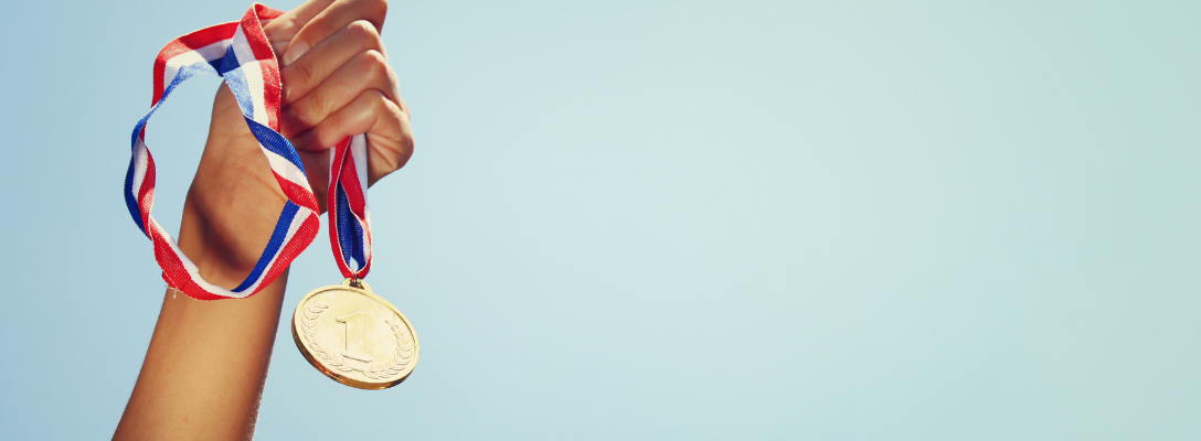 Person Holding Gold Olympic Medal
