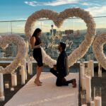 outdoor wedding proposal las vegas strip view rooftop balcony with flower heart and neon will you marry me sign