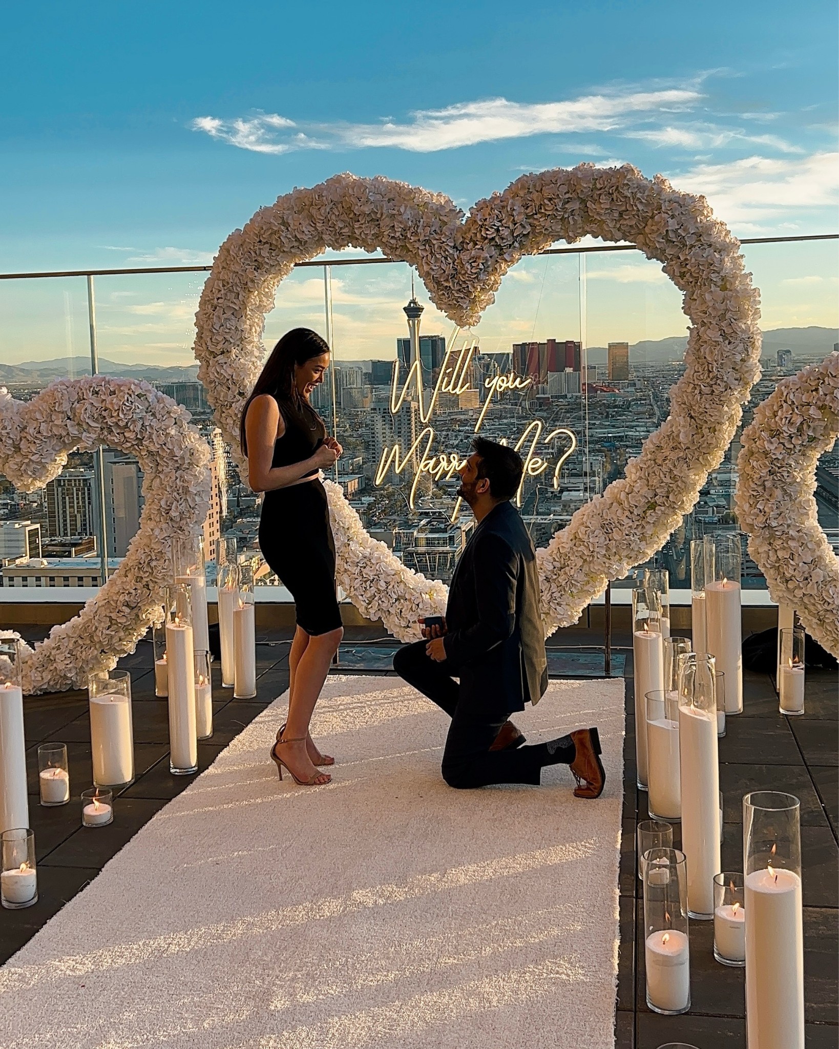 outdoor wedding proposal las vegas strip view rooftop balcony with flower heart and neon will you marry me sign